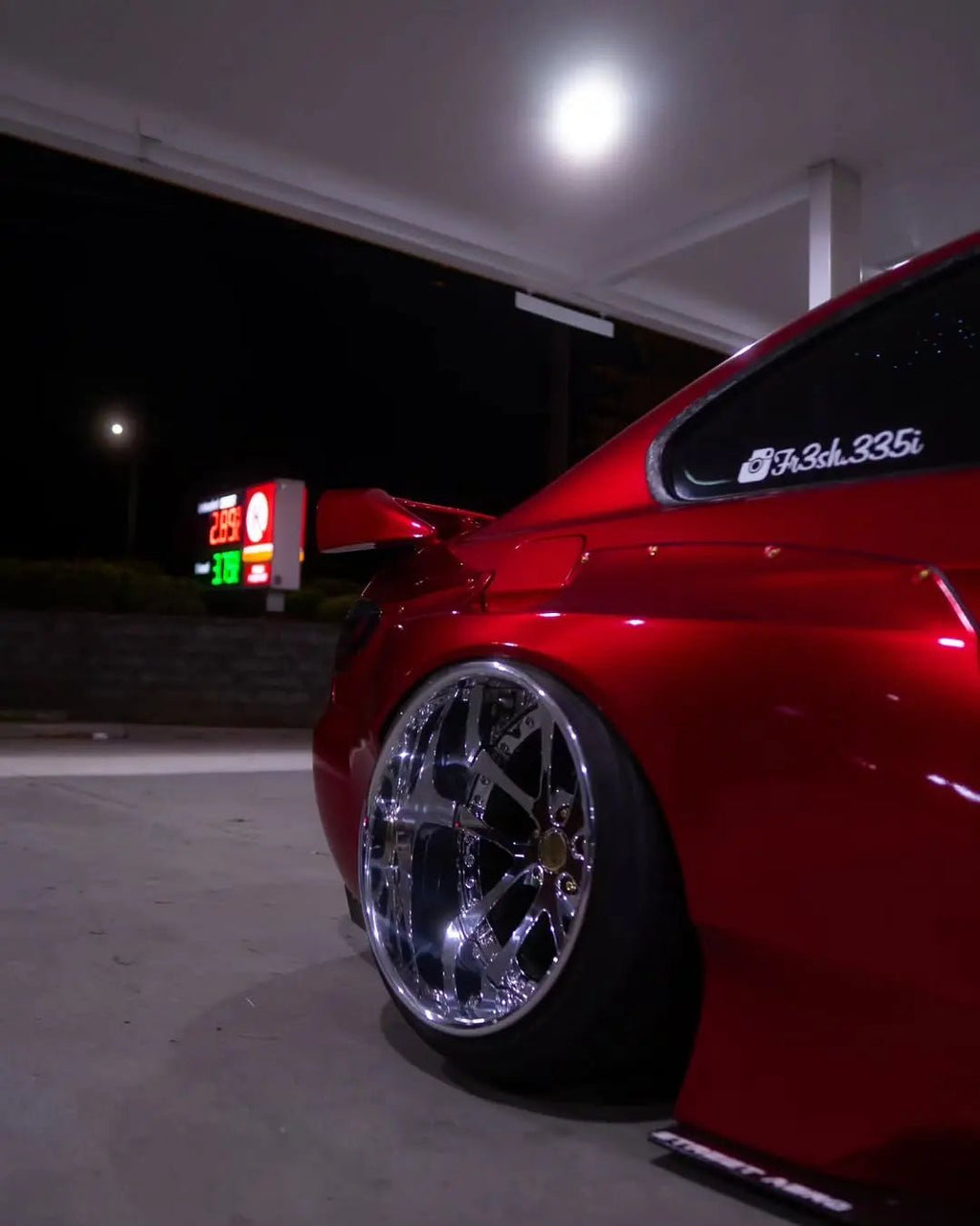 Rear-quarter right view showcasing Glossy Metallic Vampire Red on the wide fender of a BMW E92 - Kaleido