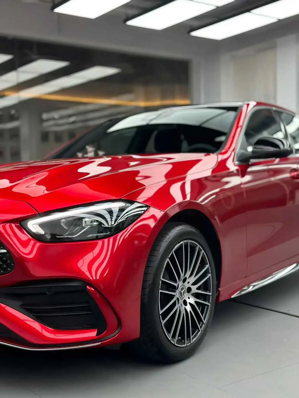 Close-up front-left view of a Mercedes-Benz C-Class (W206) in Glossy Metallic Vampire Red wrap - Kaleido