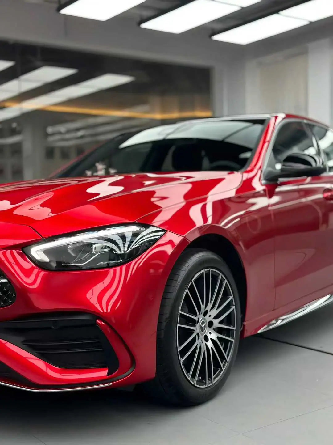 Close-up front-left view of a Mercedes-Benz C-Class (W206) in Glossy Metallic Vampire Red wrap - Kaleido