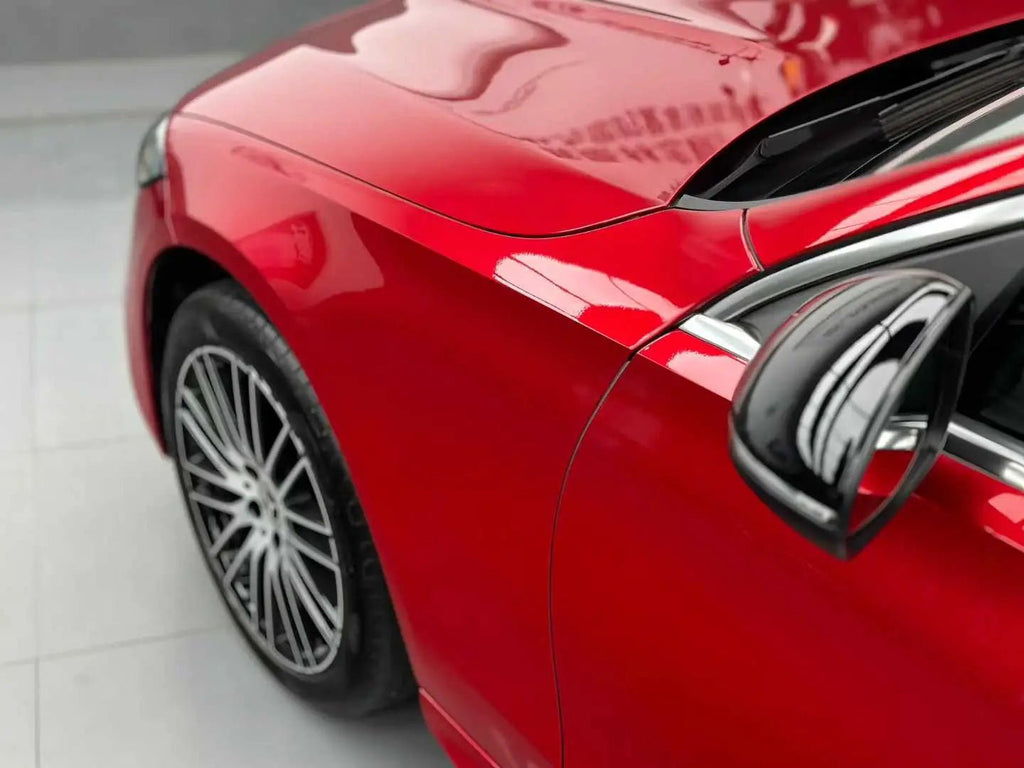Close-up of Glossy Metallic Vampire Red vinyl on the left fender of a Mercedes C-Class (W206) - Kaleido
