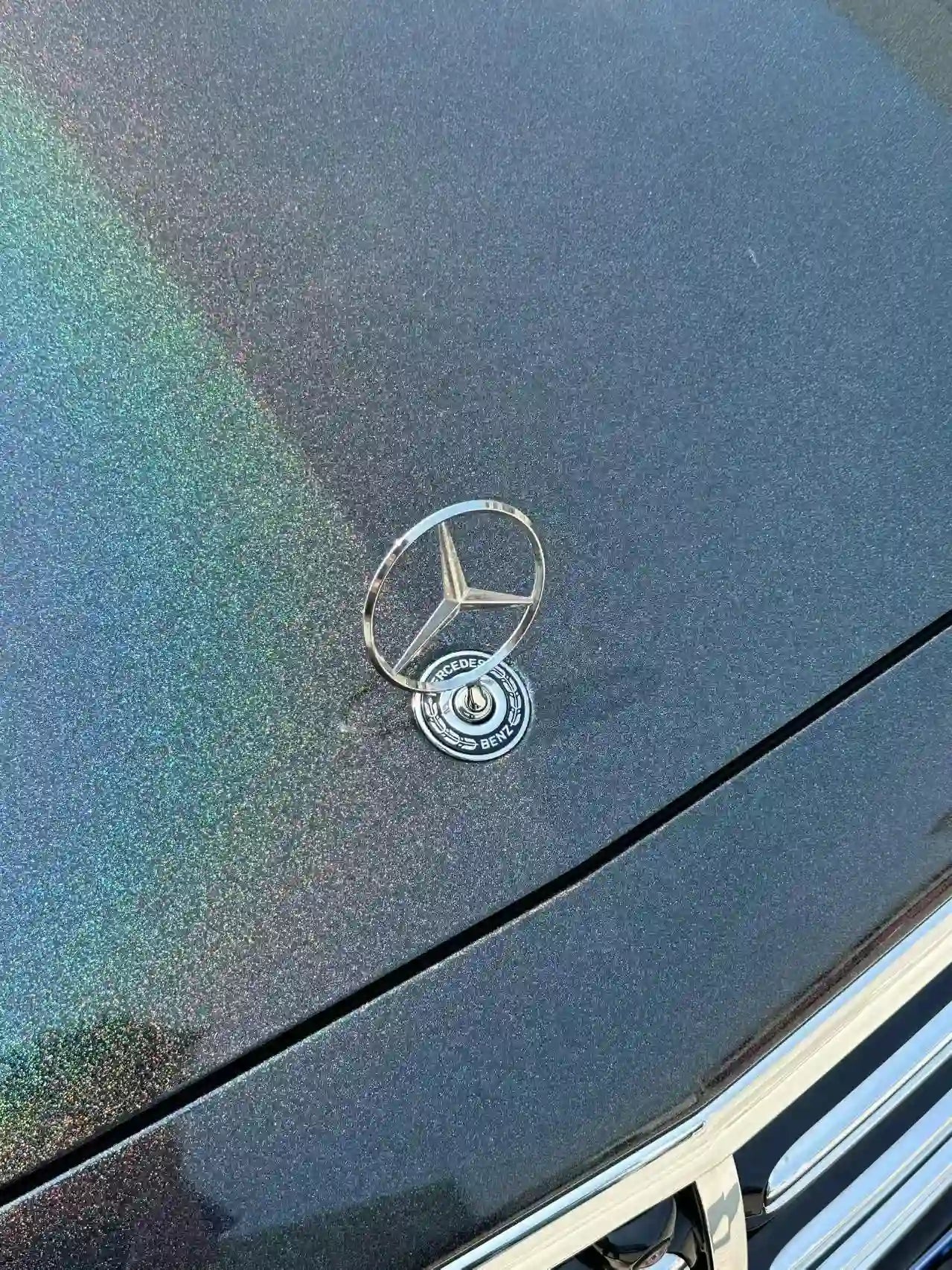 Close-up of Laser Gloss Black wrap around Mercedes-Benz E-Class hood emblem - precise cutting - Kaleido