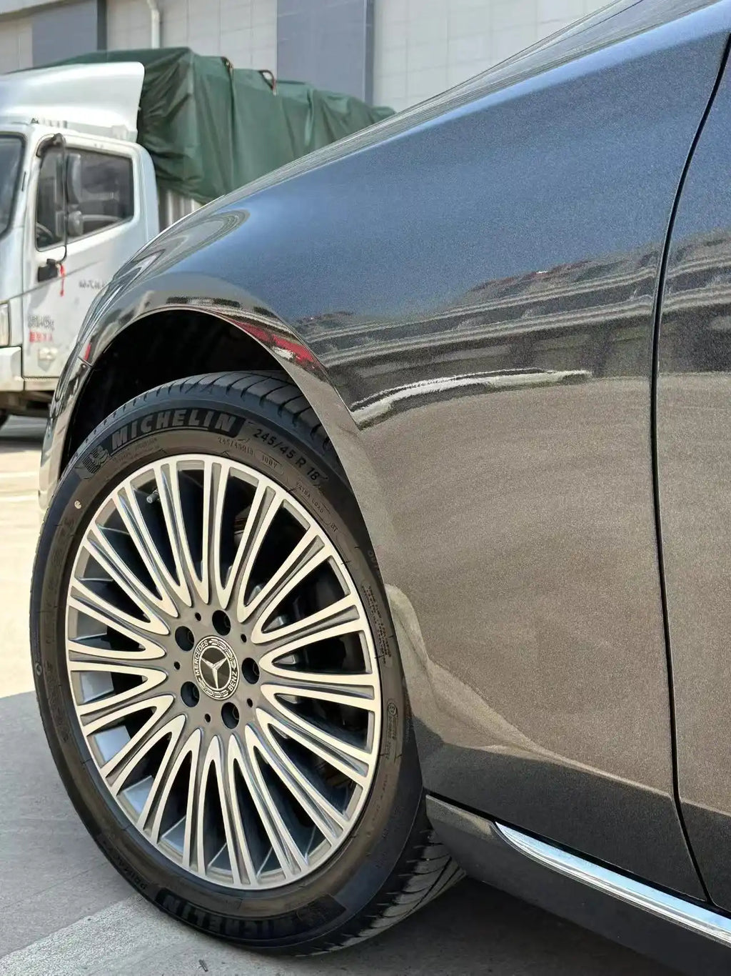 Macro detail of Laser Gloss Black vinyl on Mercedes-Benz E-Class front fender - Kaleido