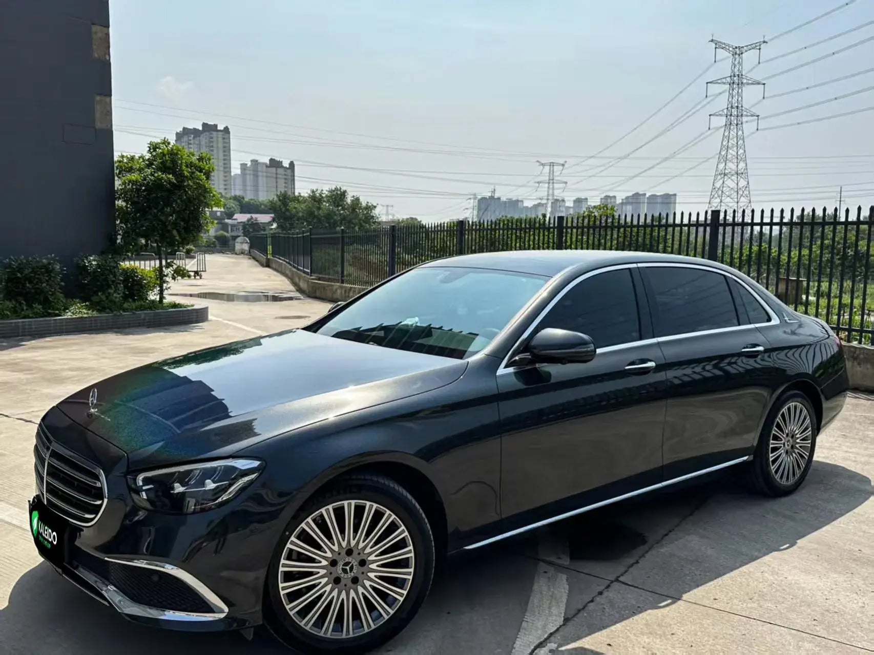 Wide front-left view of Mercedes-Benz E-Class in Laser Gloss Black vinyl wrap - Kaleido