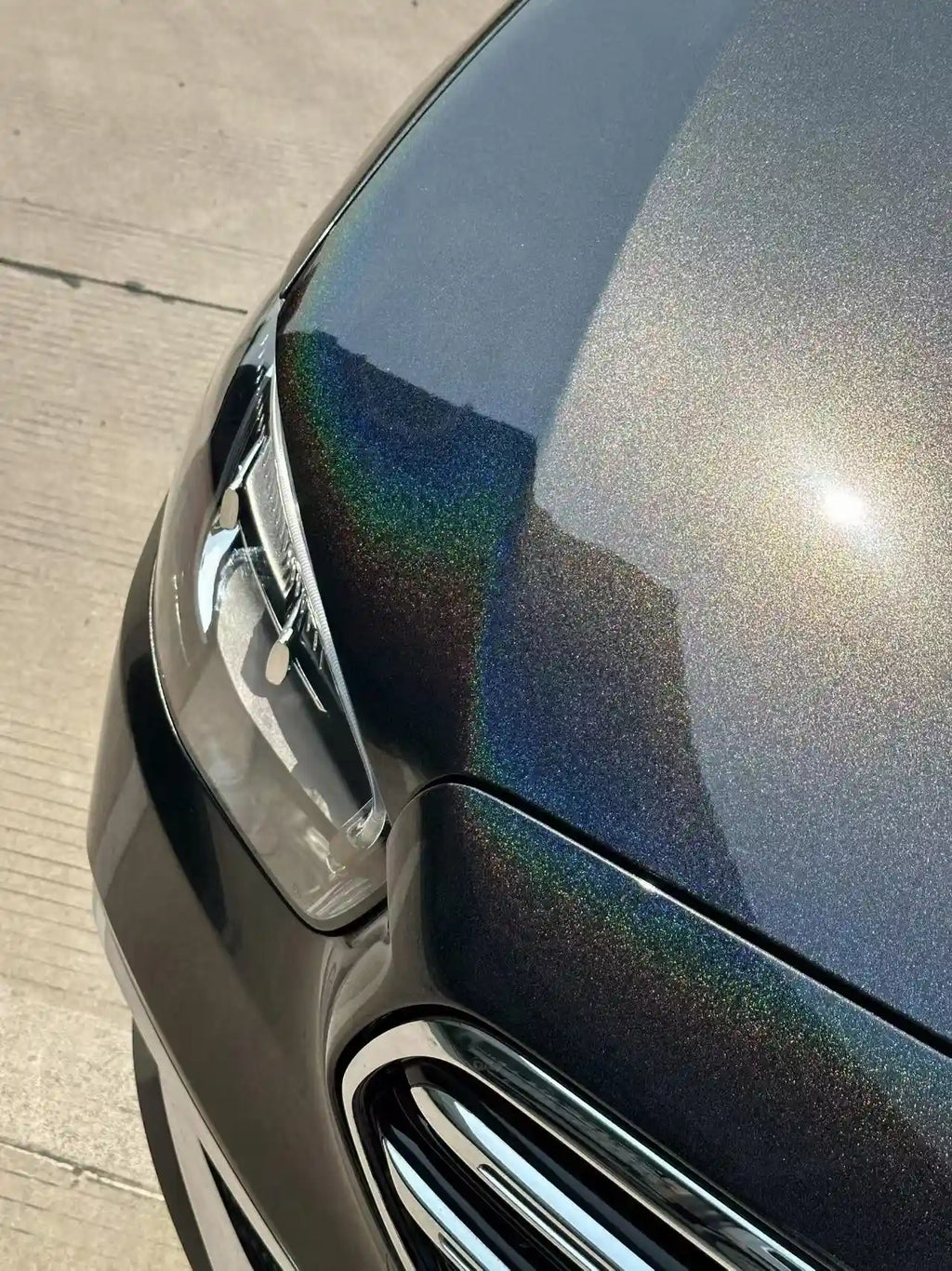 Detailed shot of Laser Gloss Black film on Mercedes-Benz E-Class front-right corner - Kaleido