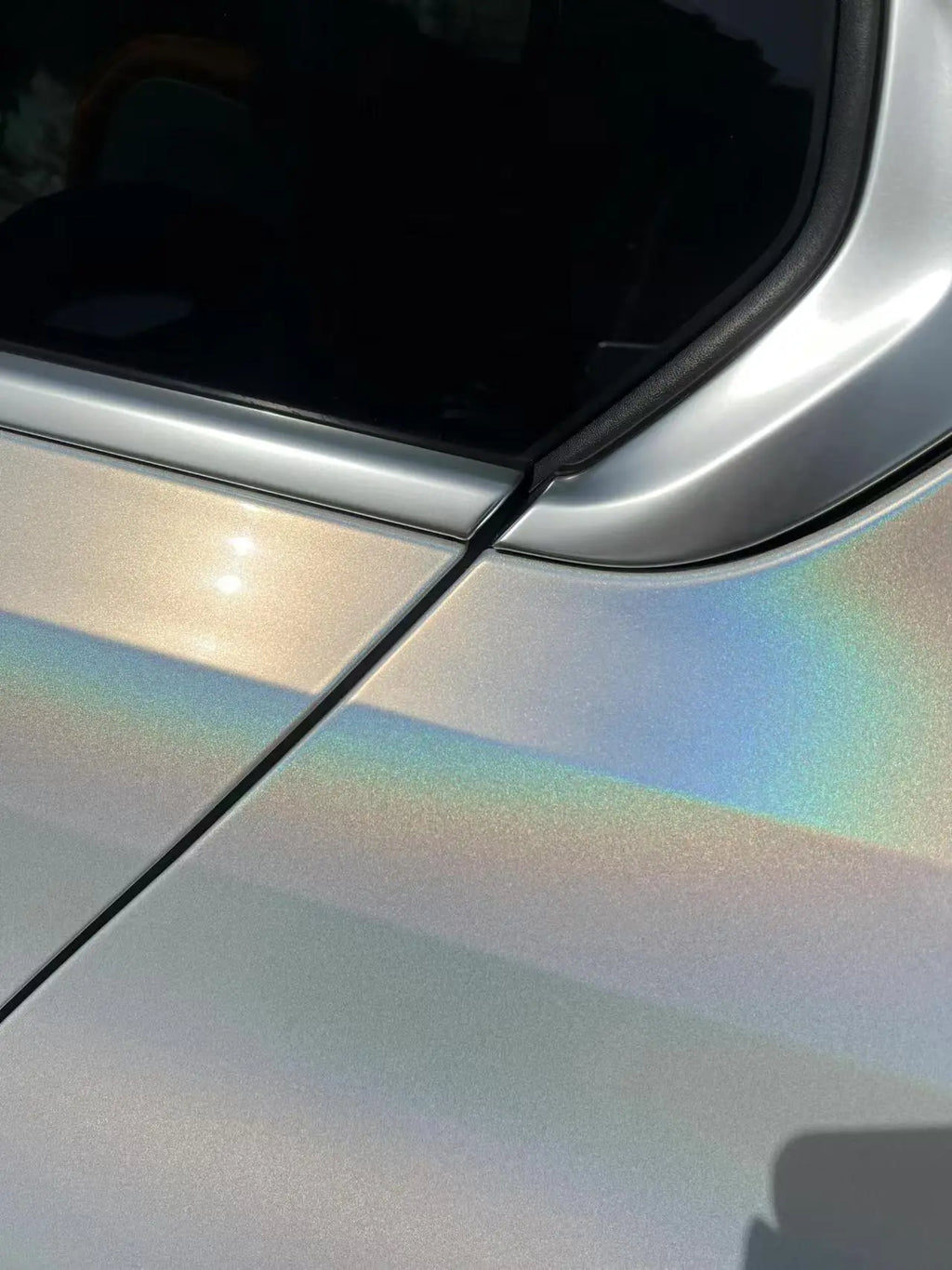 Close-up detail of Laser Gloss Prismatic White film on Audi Q2L rear fender - Kaleido