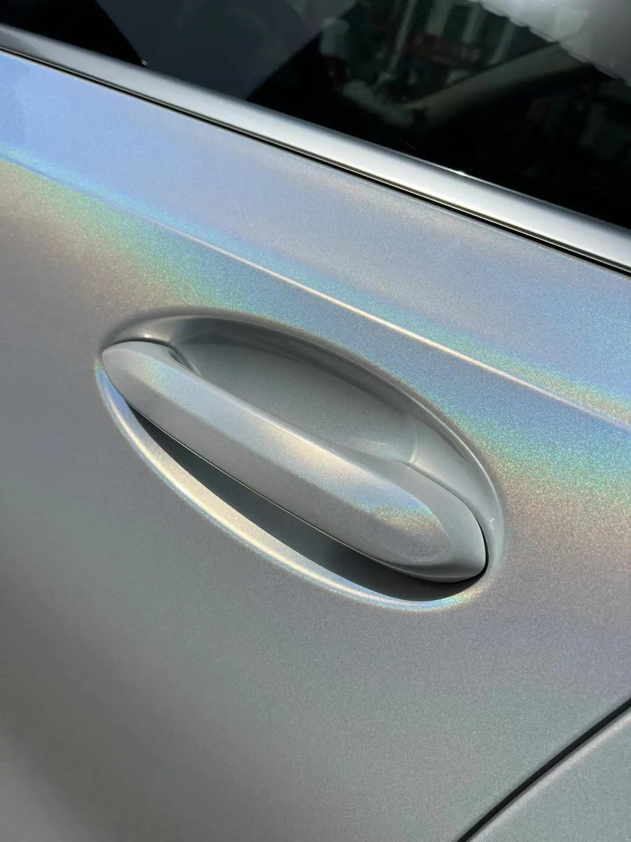 Detail shot of Laser Gloss Prismatic White vinyl on BMW 3 Series door handle - Kaleido