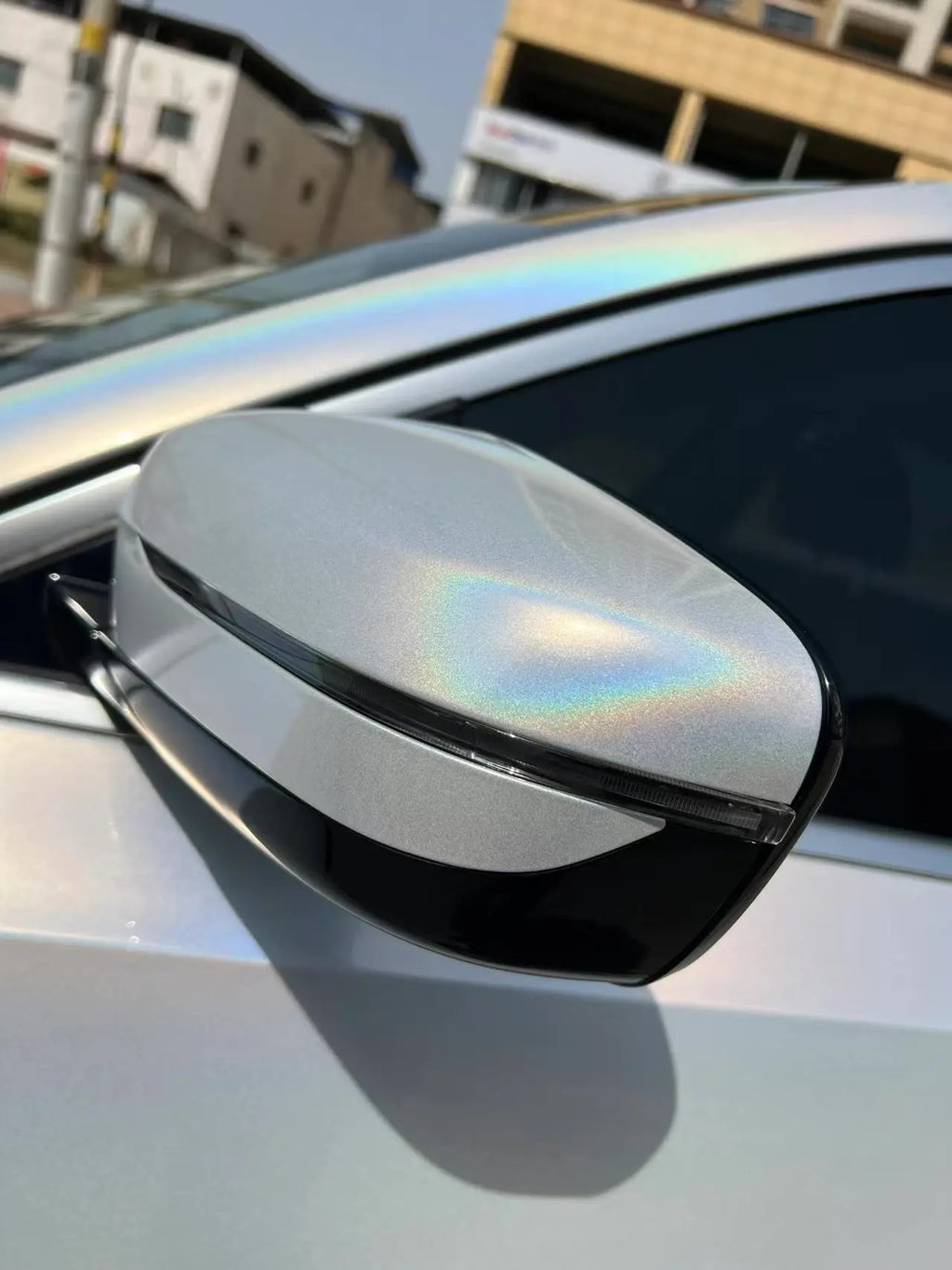 Extreme close-up of Laser Gloss Prismatic White vinyl on BMW 3 Series side mirror - Kaleido
