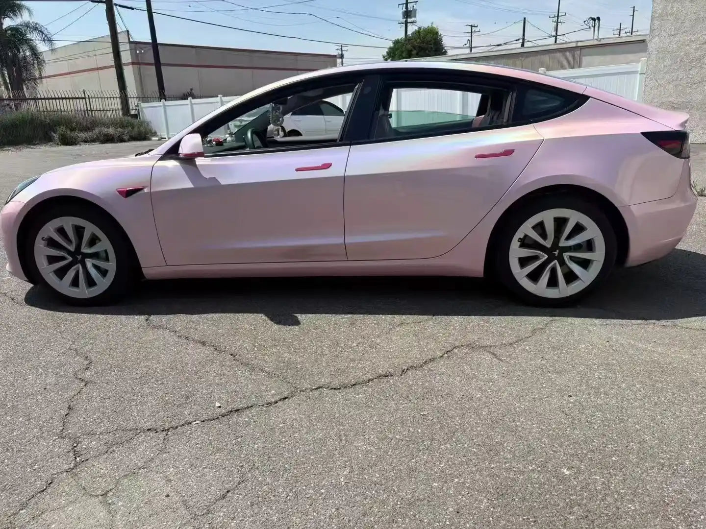 Tesla Model 3 in Laser Gloss Rouge Pink vinyl - left side outdoor view showing full holographic effect - Kaleido