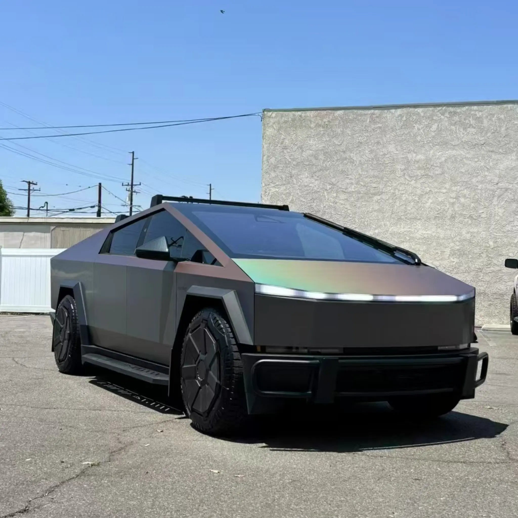 Close-up of Laser Satin Gray vinyl on Cybertruck front-right corner - matte base and rainbow shift detail - Kaleido