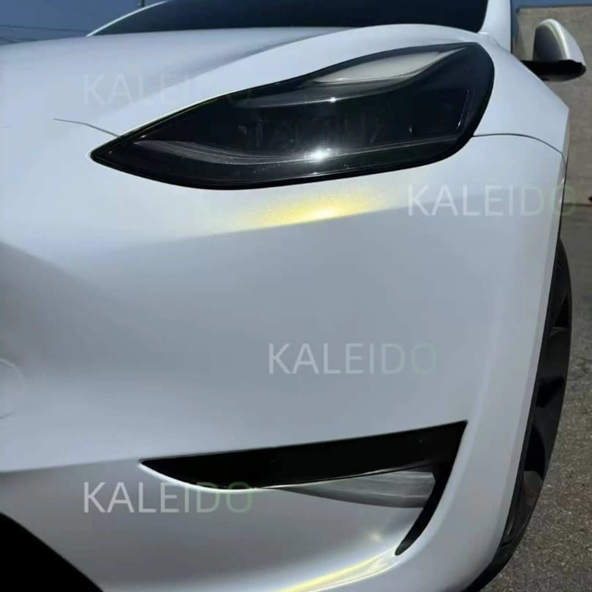 Close-up of Matte Diamond Iridescent White Gold vinyl on Tesla Model 3 front-left corner - matte texture detail - Kaleido