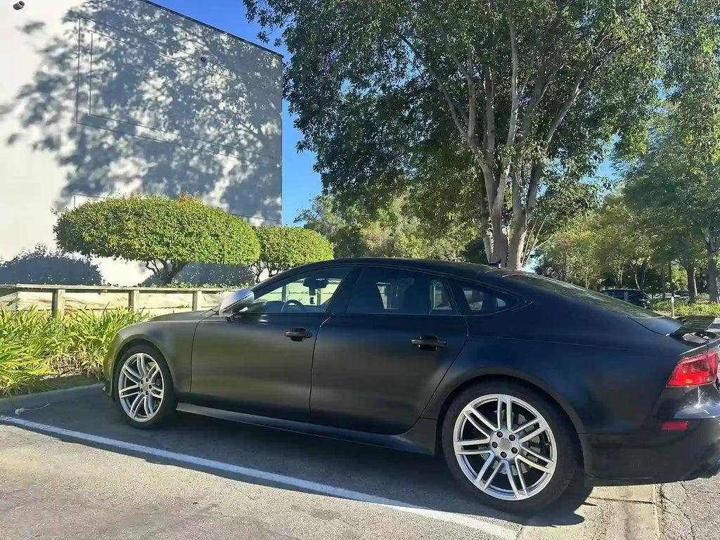 Rear-left view of Silky Noir matte wrap on Audi RS7 - outdoor natural lighting - Kaleido