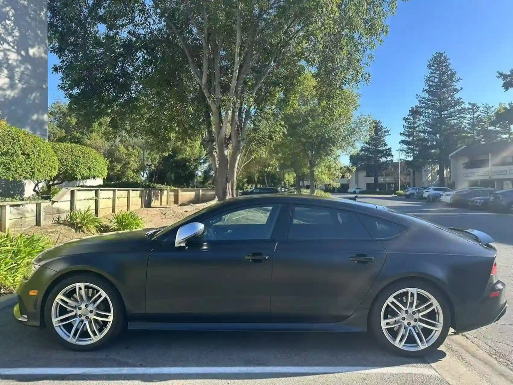 Audi RS7 side profile in Silky Noir matte vinyl - outdoor setting emphasizing fastback lines - Kaleido