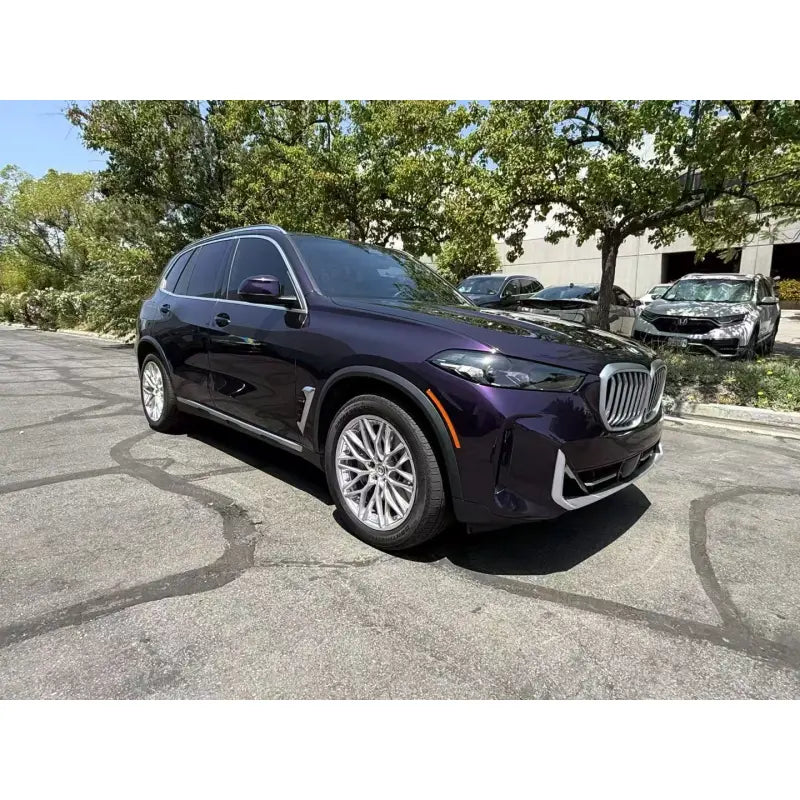 Front-right view of a BMW X5 wrapped in deep Midnight Purple Metallic gloss film - Kaleido
