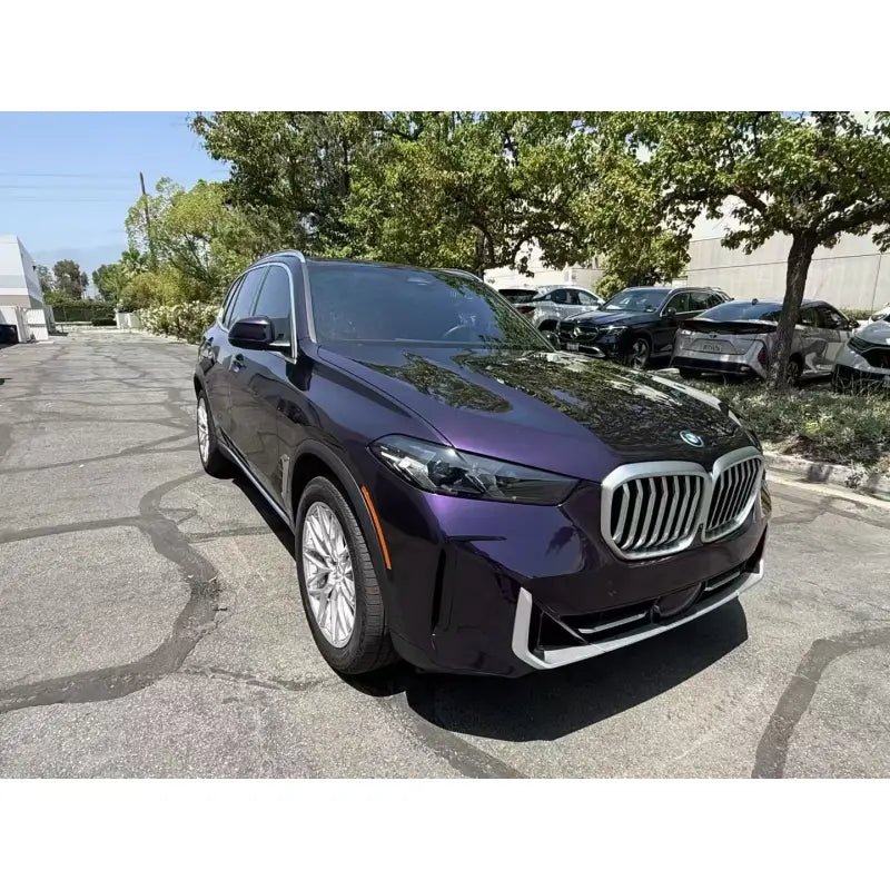 Lifestyle shot of a Midnight Purple Metallic wrapped BMW X5 in an urban setting - Kaleido