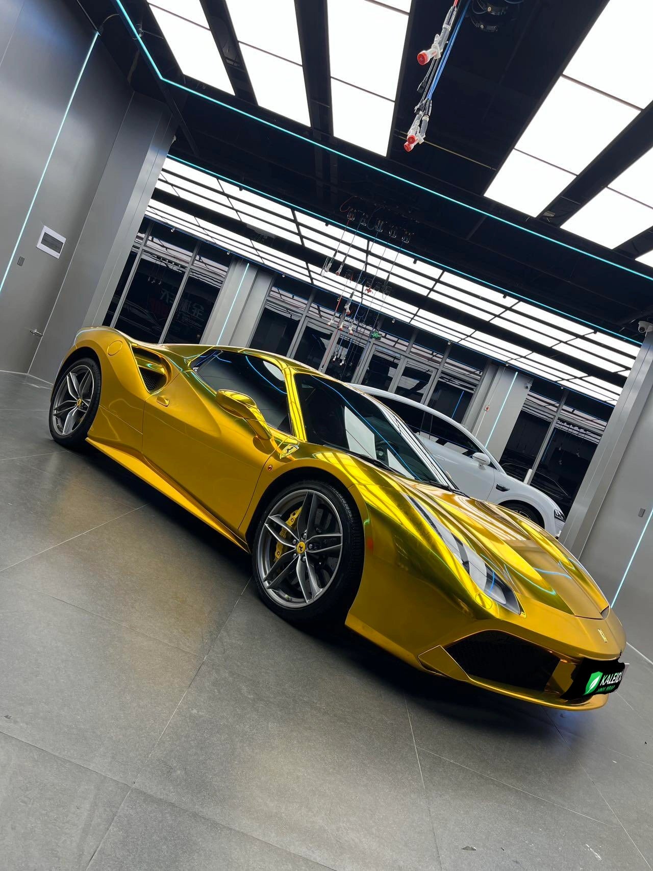 Mirror Chrome Gold wrap on a Ferrari 488 GTB - front-right angle showcasing reflective gold surface - Kaleido
