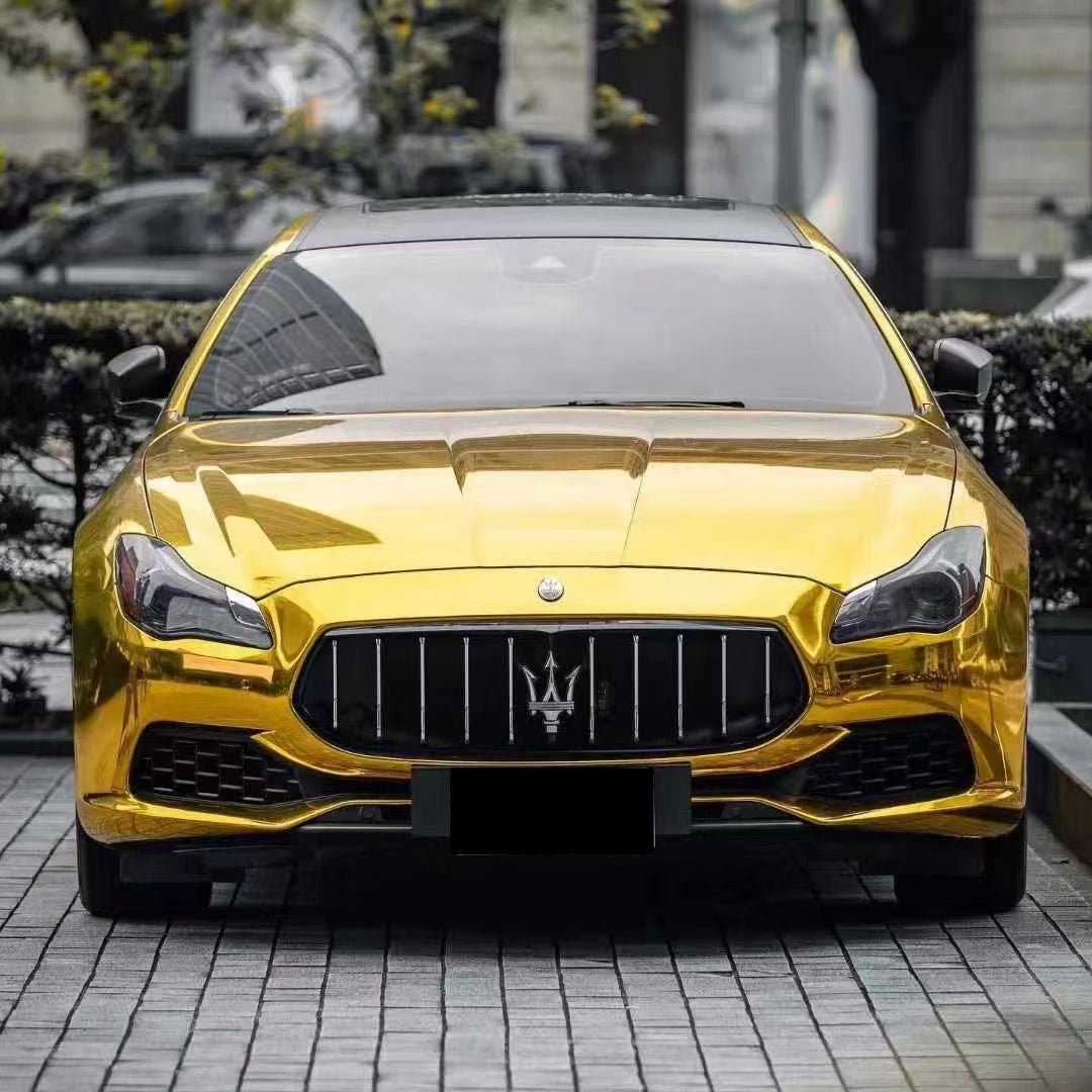 Front view of a Maserati Quattroporte luxury sedan in Mirror Chrome Gold wrap - Kaleido
