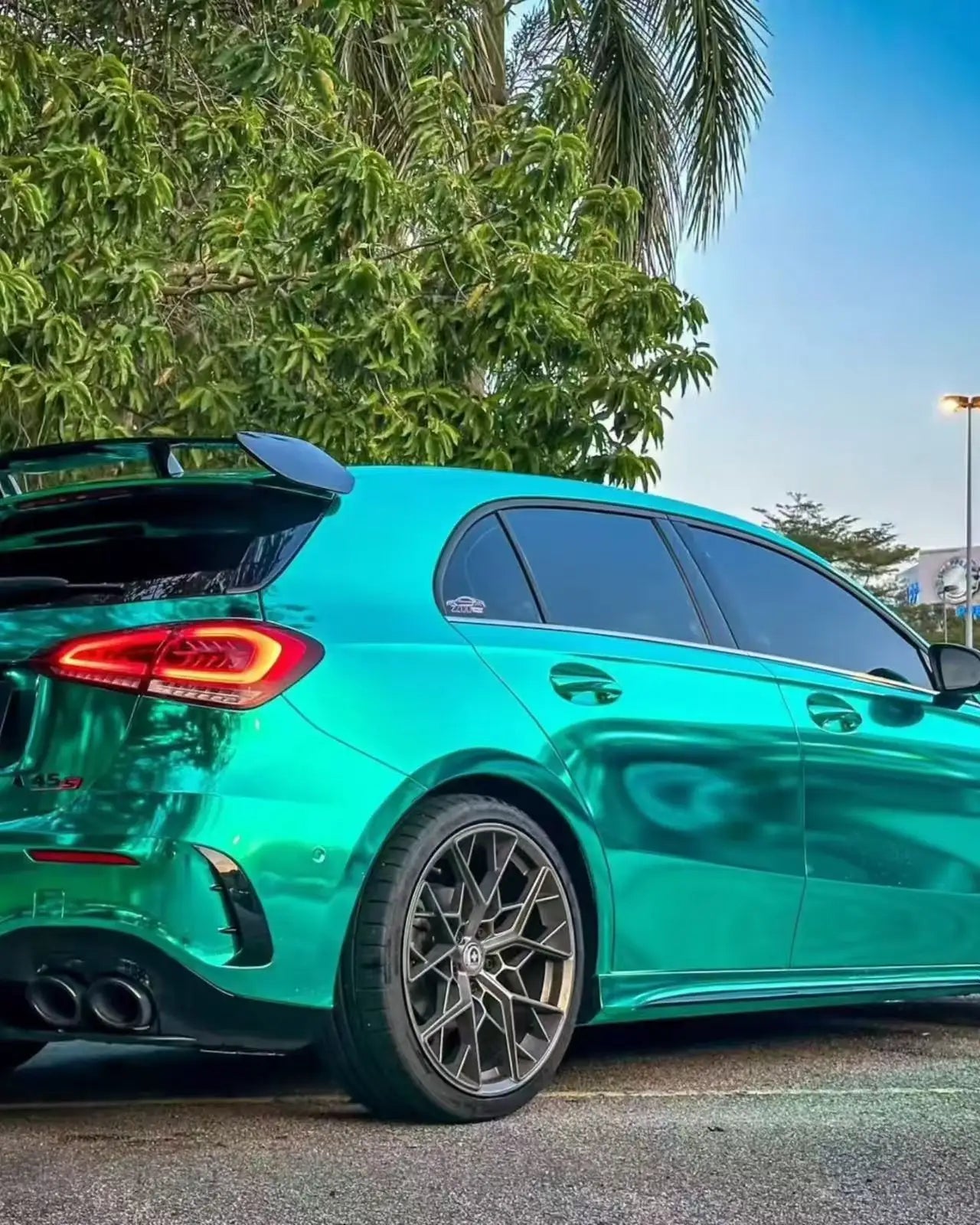 Mirror Chrome Green wrap on Mercedes-AMG A45 rear-right - showcasing AMG exhaust - Kaleido