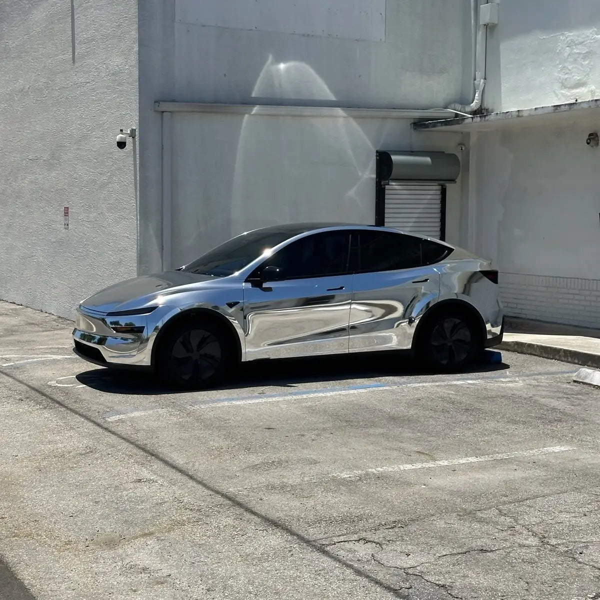 Mirror Chrome Silver vinyl on Tesla Model Y - front-left angle showing reflection - Kaleido