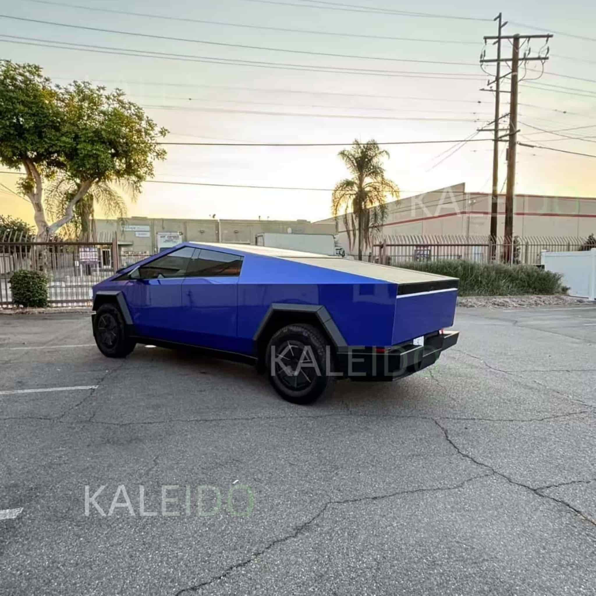 Portimao Blue Metallic wrap, rear-left angle of the angular Tesla Cybertruck - Kaleido