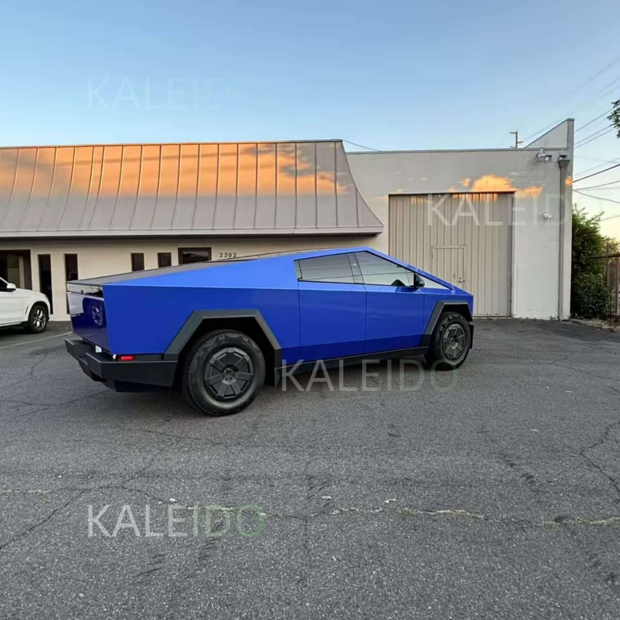 Rear-right view of the Tesla Cybertruck with a vibrant Portimao Blue Metallic vinyl wrap - Kaleido