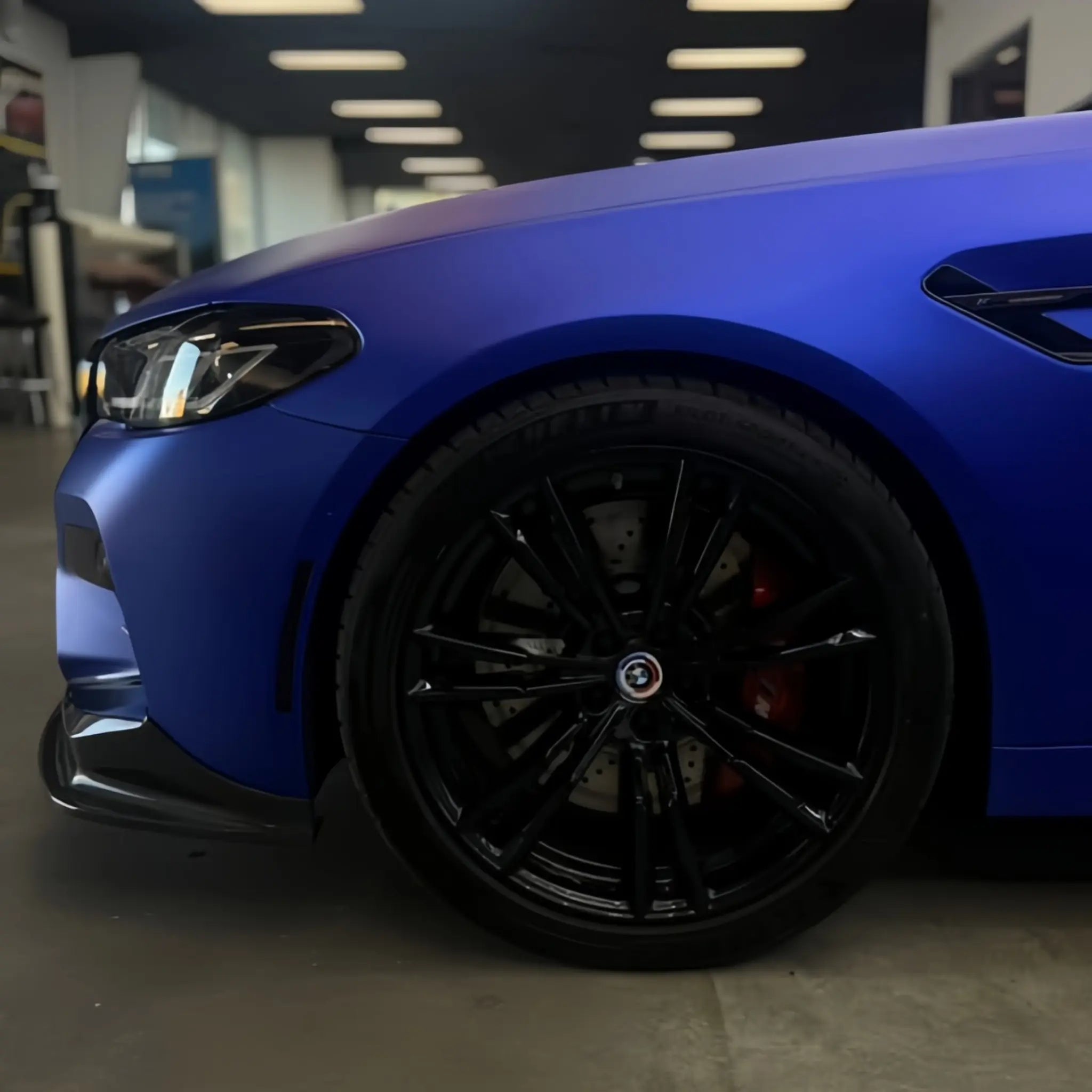 Satin Chrome Abyss Blue wrap on BMW M5 front-right corner - deep matte chrome blue finish on sports sedan - Kaleido
