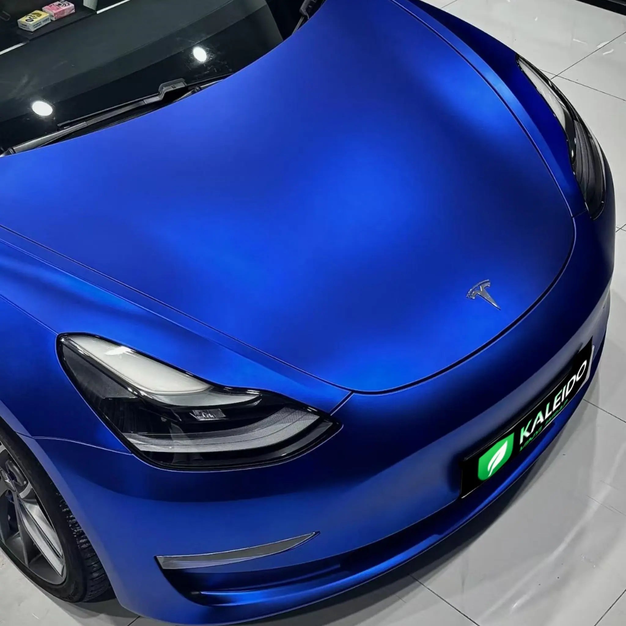 Macro detail of Satin Chrome Abyss Blue wrap on Tesla Model 3 hood - satin texture - Kaleido