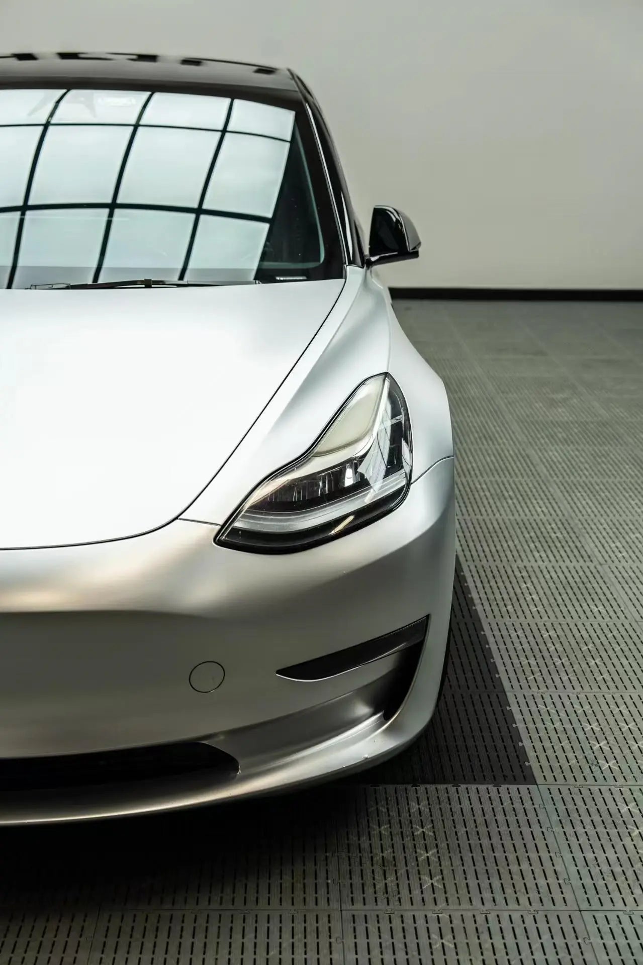Front-left three-quarter view of a Tesla Model 3 wrapped in Satin Chrome Alexander Silver - Kaleido
