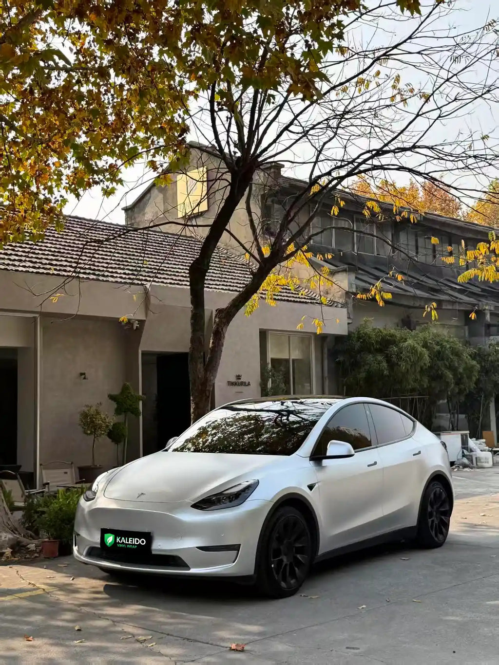 Front-left view of a Tesla Model Y in Satin Chrome Alexander Silver vinyl - Kaleido