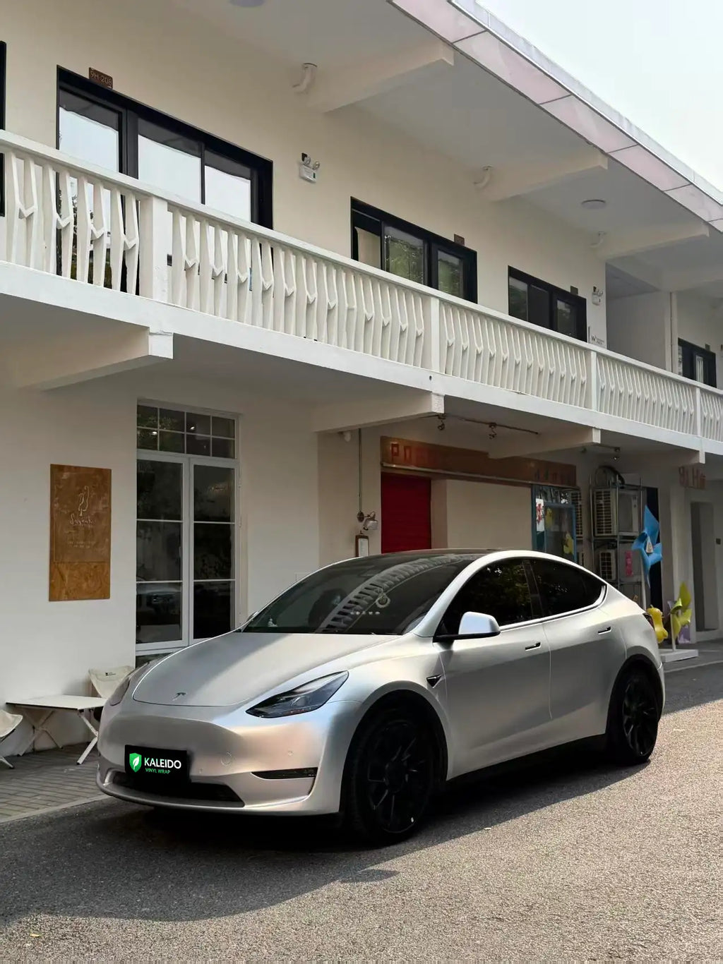 Wide front-left view of a Tesla Model Y in Satin Chrome Alexander Silver wrap - Kaleido