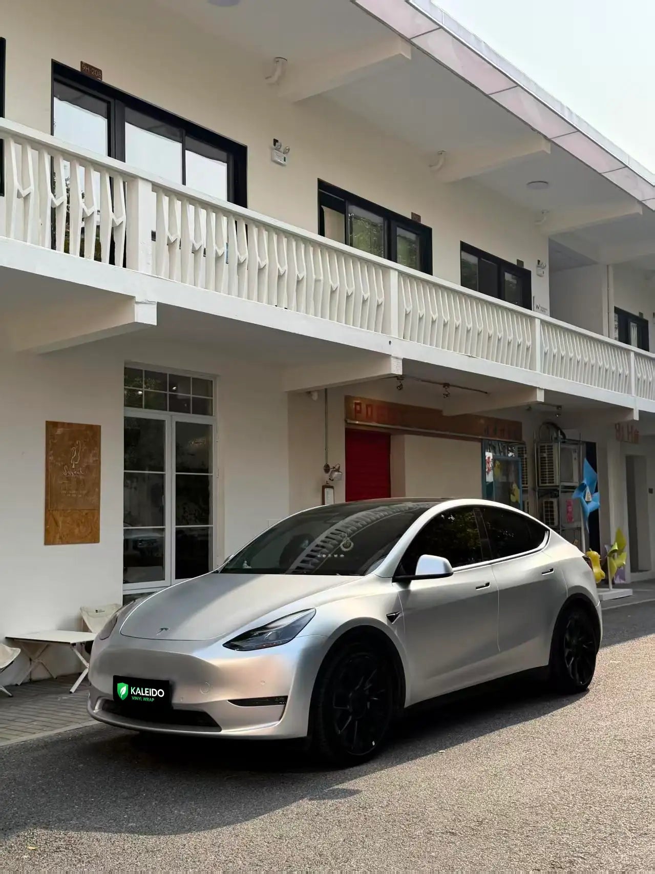 Wide front-left view of a Tesla Model Y in Satin Chrome Alexander Silver wrap - Kaleido