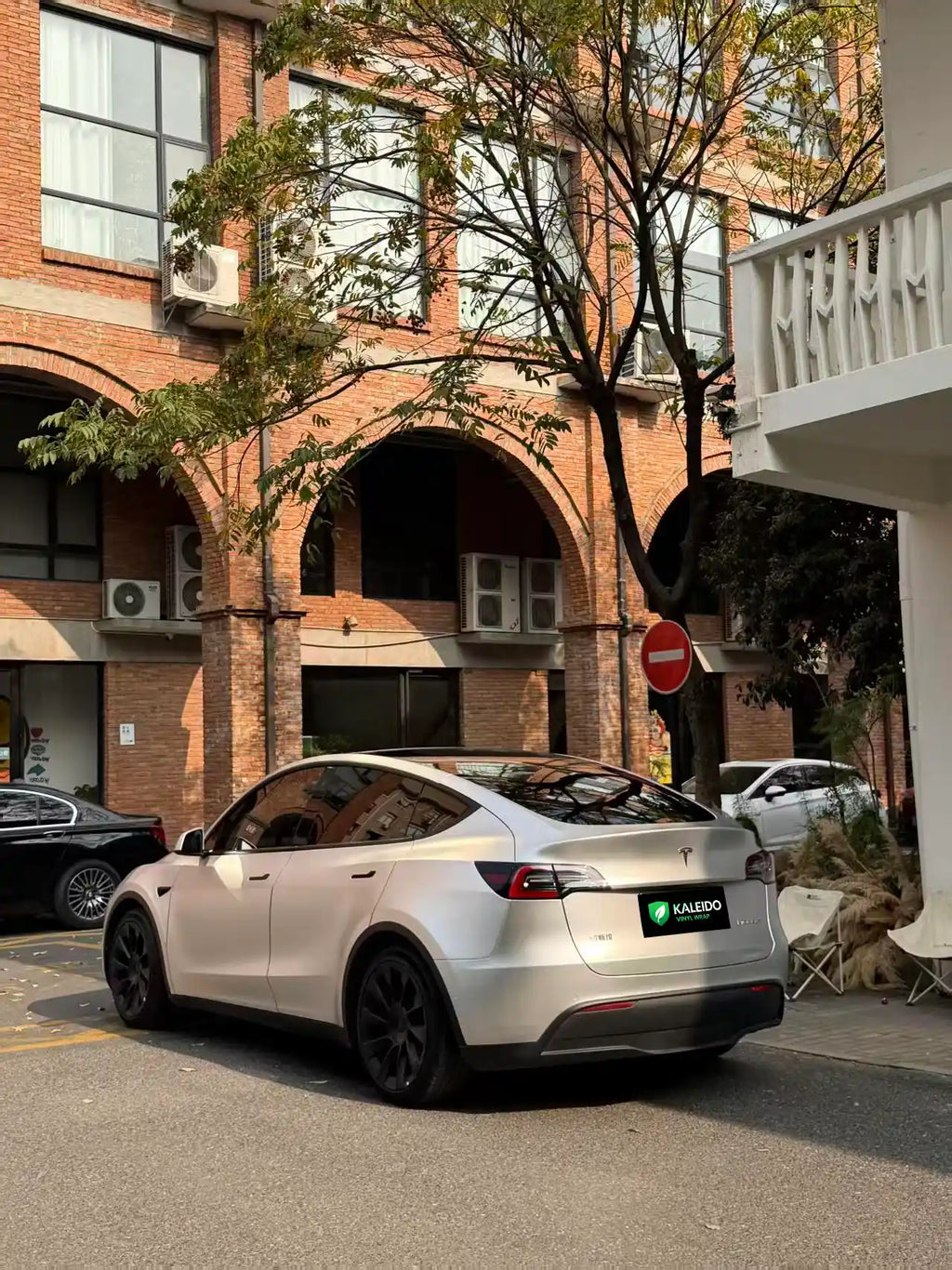 Rear-left angle of a Tesla Model Y with Satin Chrome Alexander Silver wrap - Kaleido