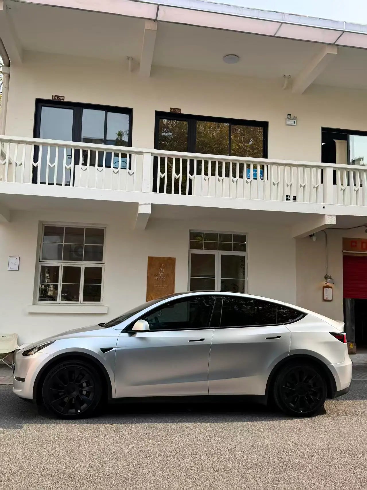 Side profile of a Tesla Model Y SUV in Satin Chrome Alexander Silver vinyl wrap - Kaleido
