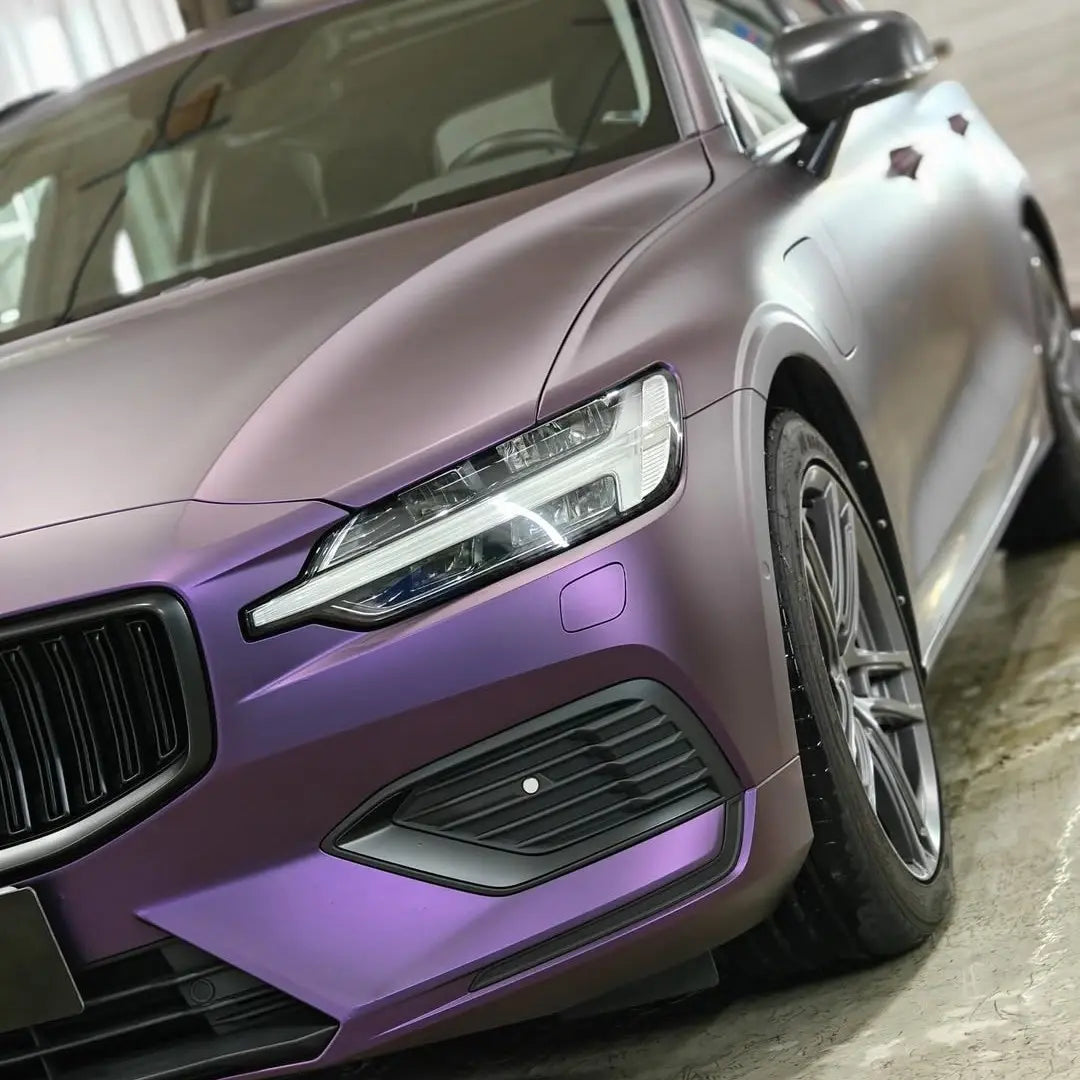 Close-up front-left detail of Satin Chrome Black Purple vinyl on a Volvo V60 wagon - Kaleido