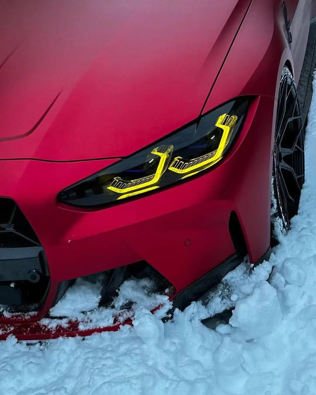 Macro detail of Satin Chrome Romanee Red film around BMW M3 front-left headlight - Kaleido