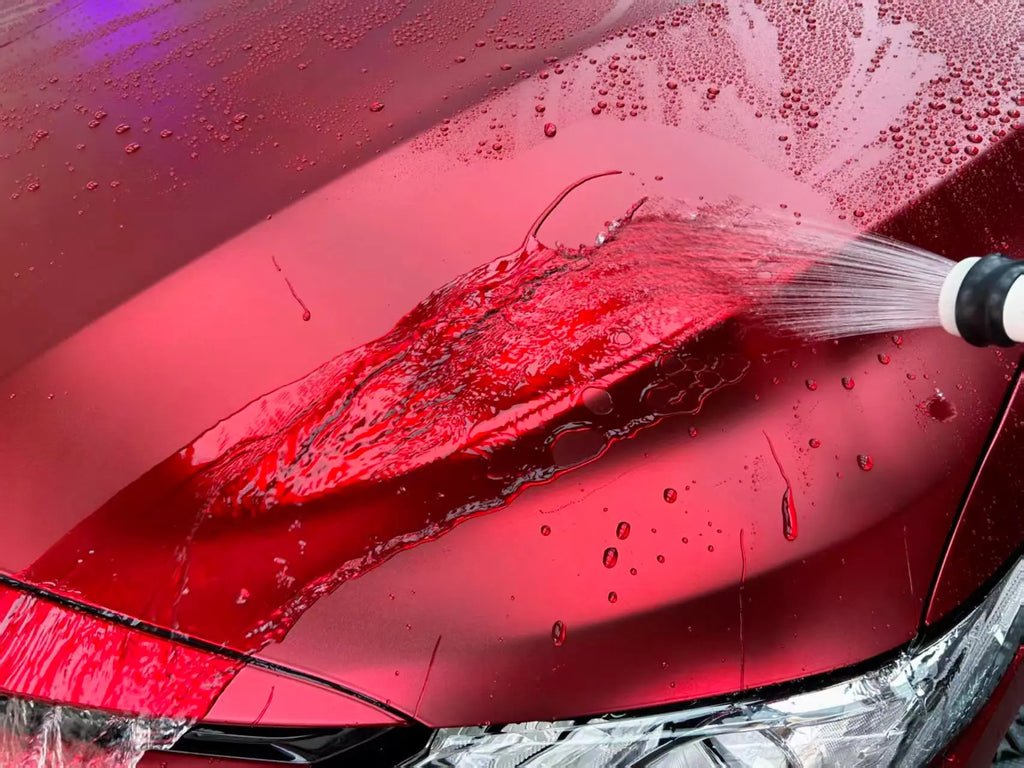 Satin Chrome Romanee Red vinyl on BMW M3 hood with water droplets - showcasing hydrophobic effect - Kaleido