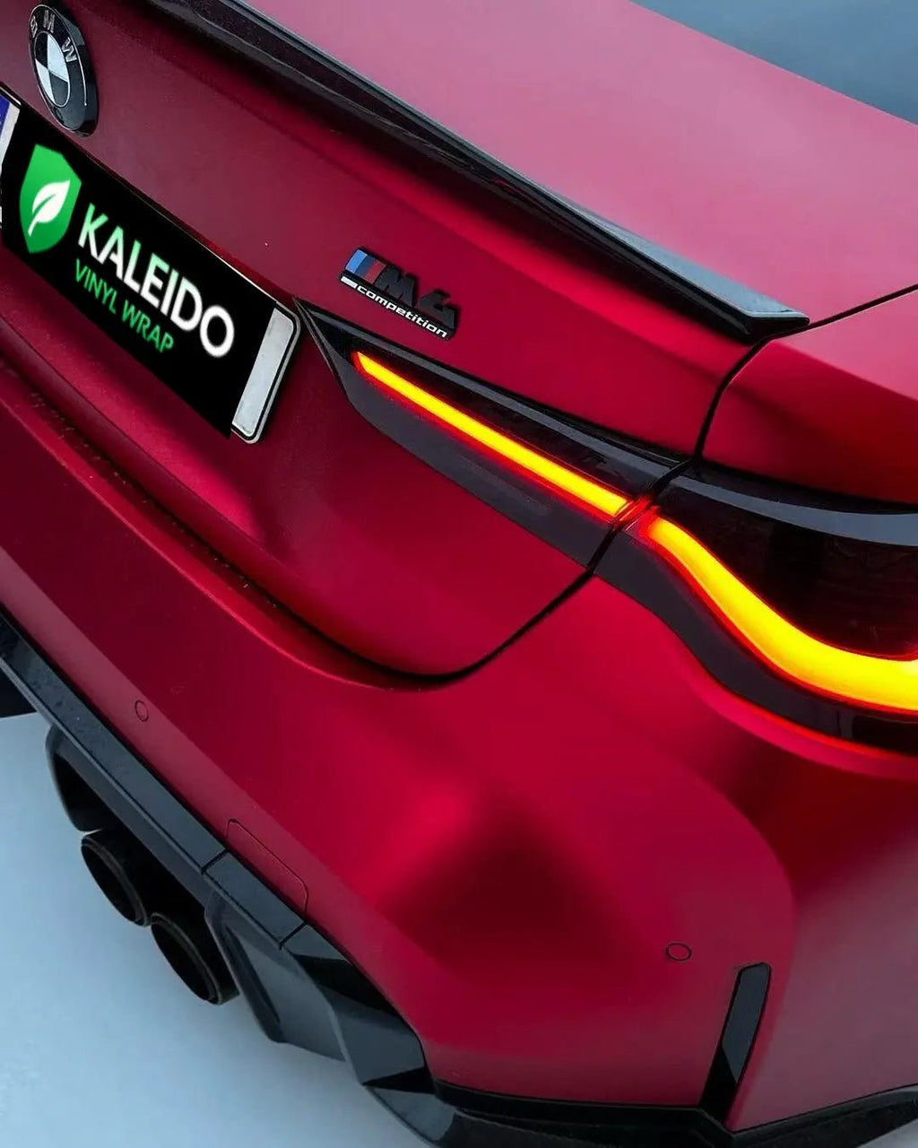 Close-up of Satin Chrome Romanee Red wrap on BMW M3 rear bumper - Kaleido
