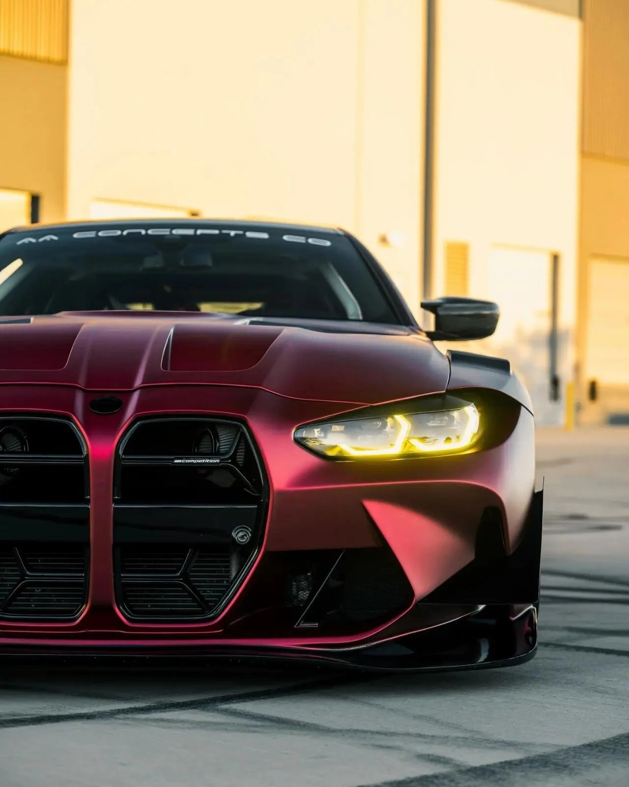 Close-up of Satin Chrome Romanee Red wrap on BMW M4 front-left headlight - Kaleido