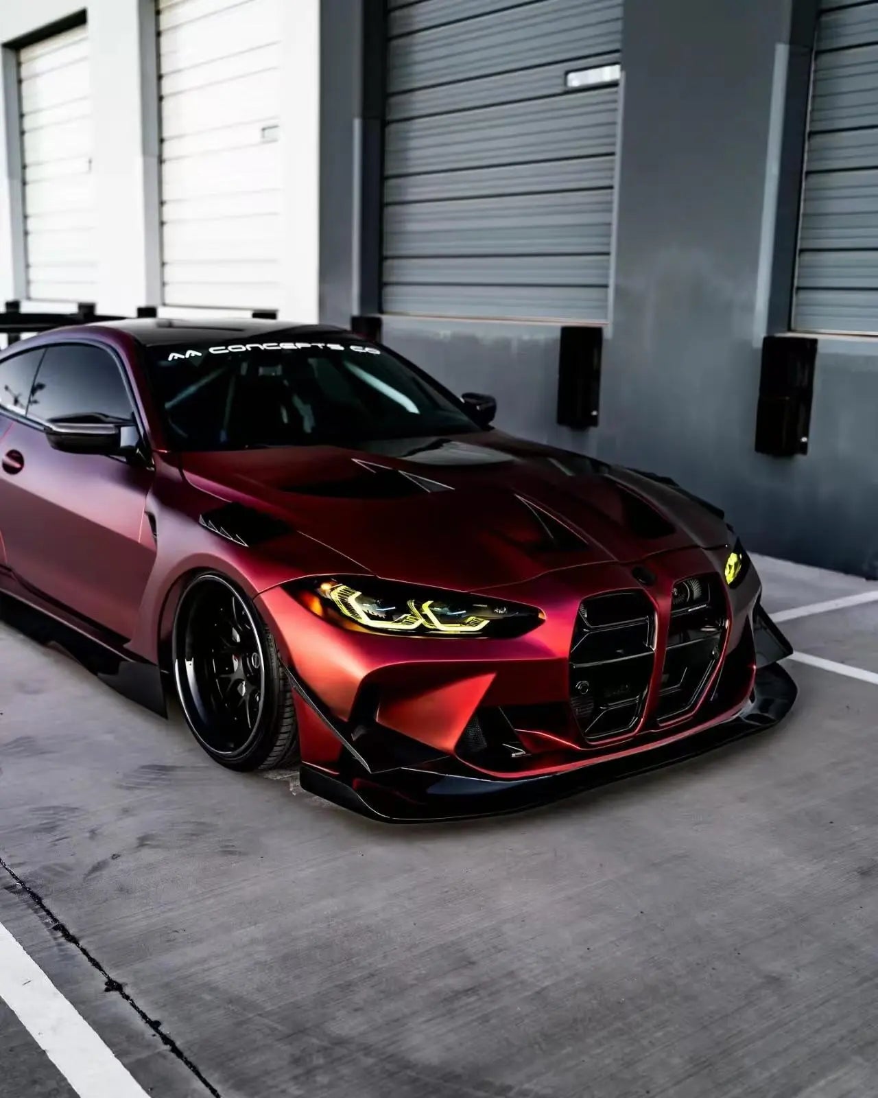 Close-up of Satin Chrome Romanee Red wrap on BMW M4 front-right bumper - Kaleido