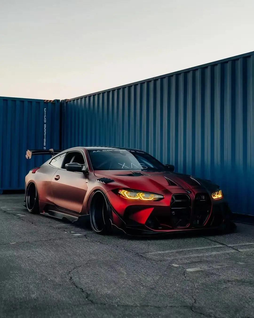 Wide front-right view of BMW M4 in Satin Chrome Romanee Red matte chrome wrap - Kaleido