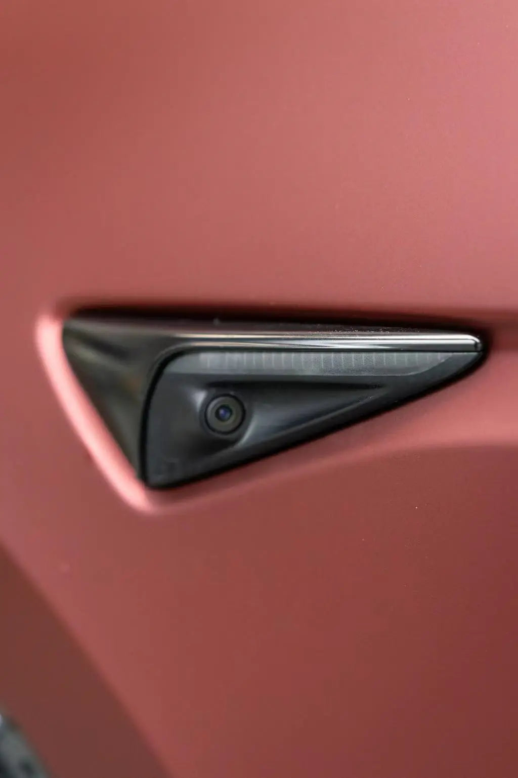 Close-up of Satin Chrome Silk Red film on Tesla Model Y fender - matte metallic texture - Kaleido