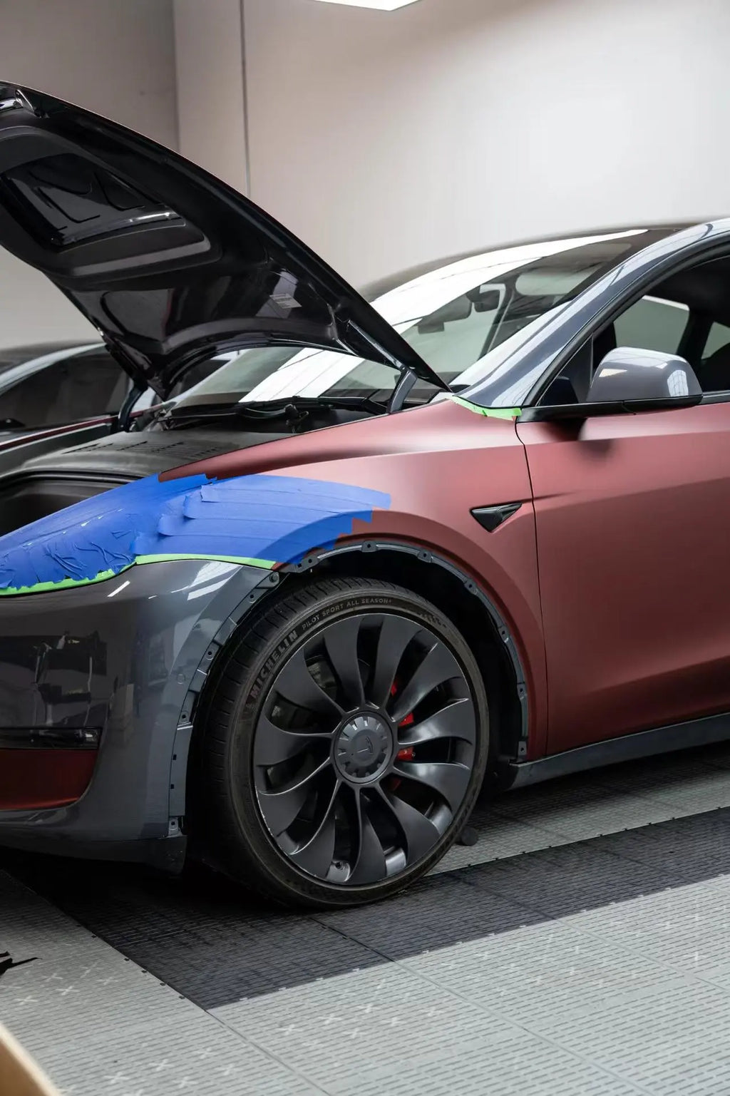 Macro detail of Satin Chrome Silk Red wrap around Tesla Model Y front-left headlight - Kaleido