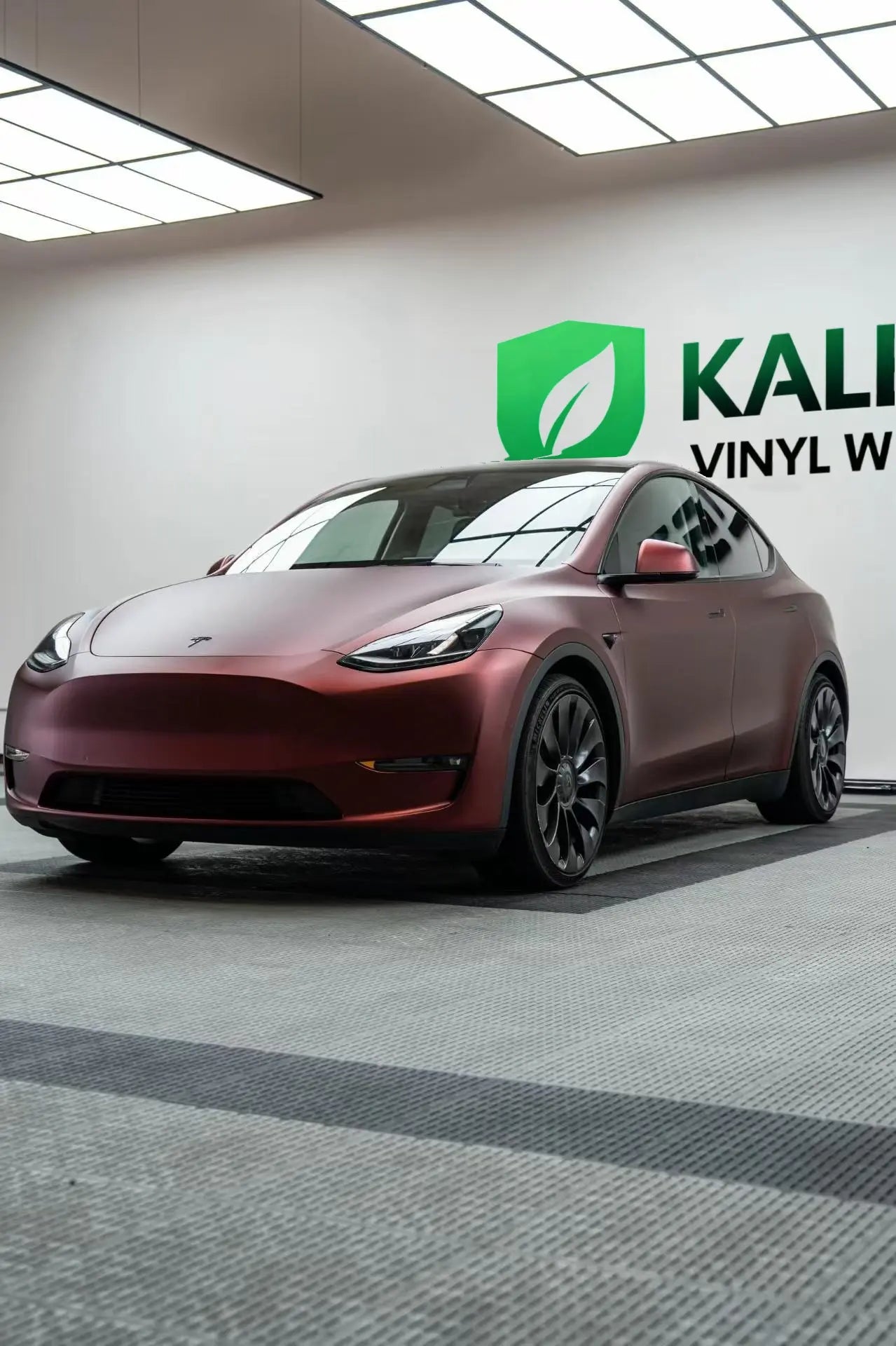 Wide front-left view of Tesla Model Y in Satin Chrome Silk Red vinyl wrap - Kaleido