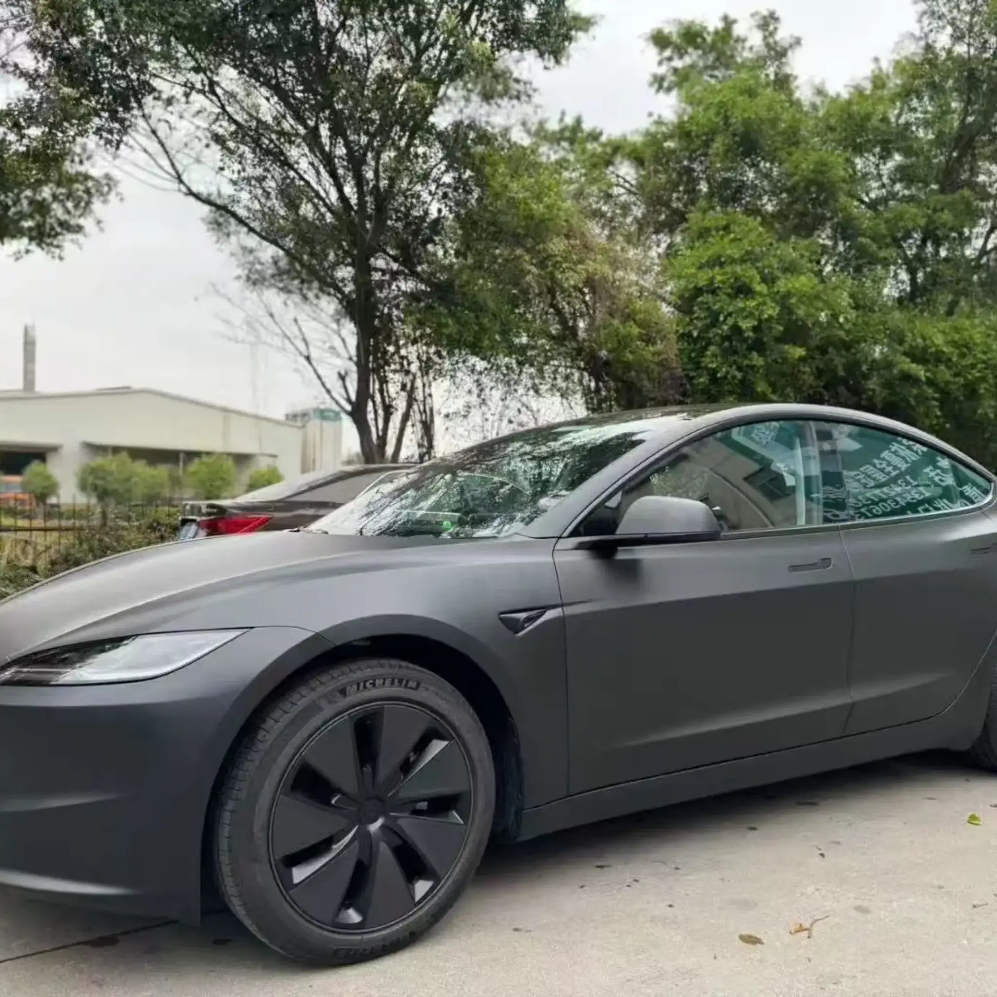 Front-left close-up of Tesla Model 3 in Stealth Matte Black vinyl - deep non-gloss black finish - Kaleido
