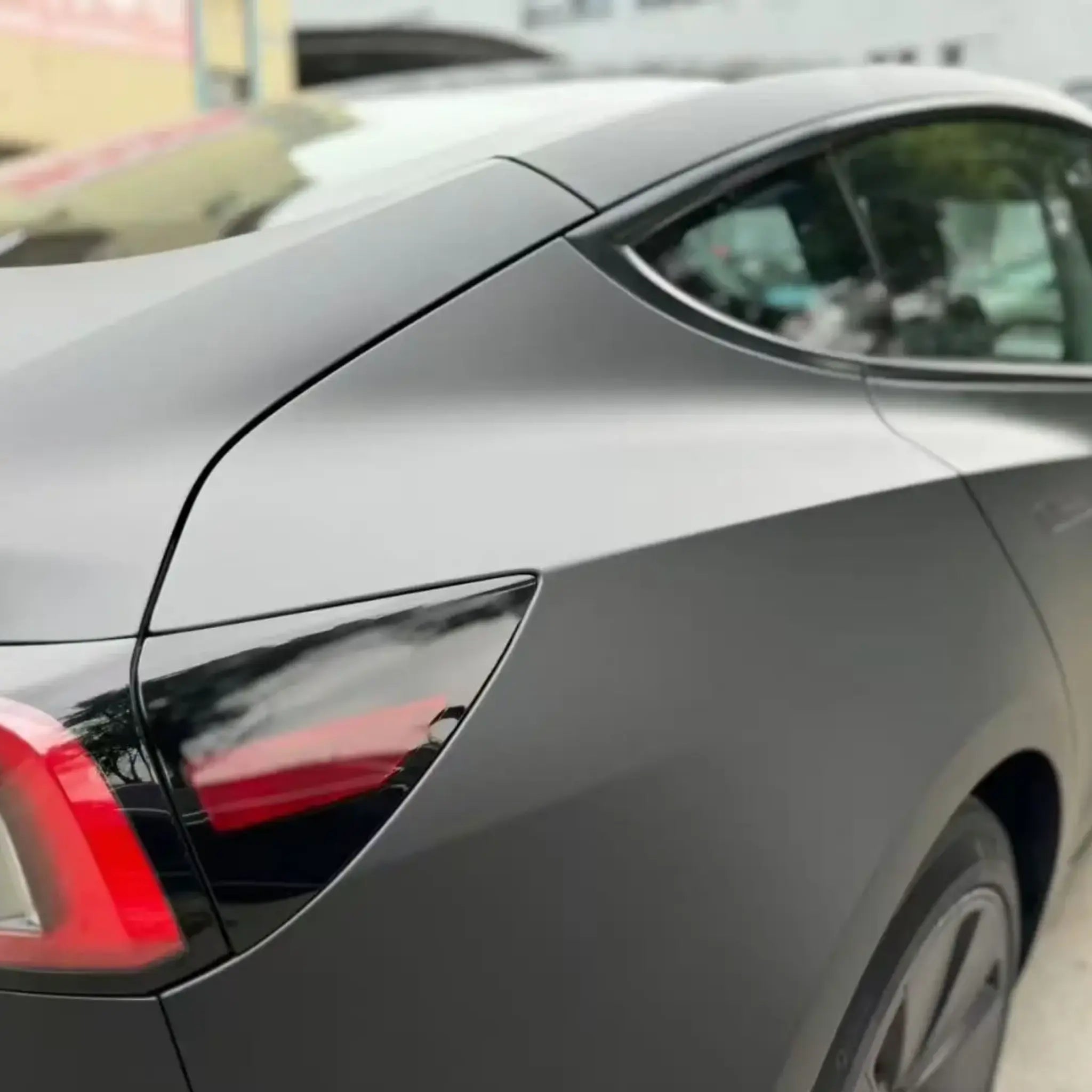 Close-up of Stealth Matte Black wrap on Tesla Model 3 right rear quarter panel - texture detail - Kaleido
