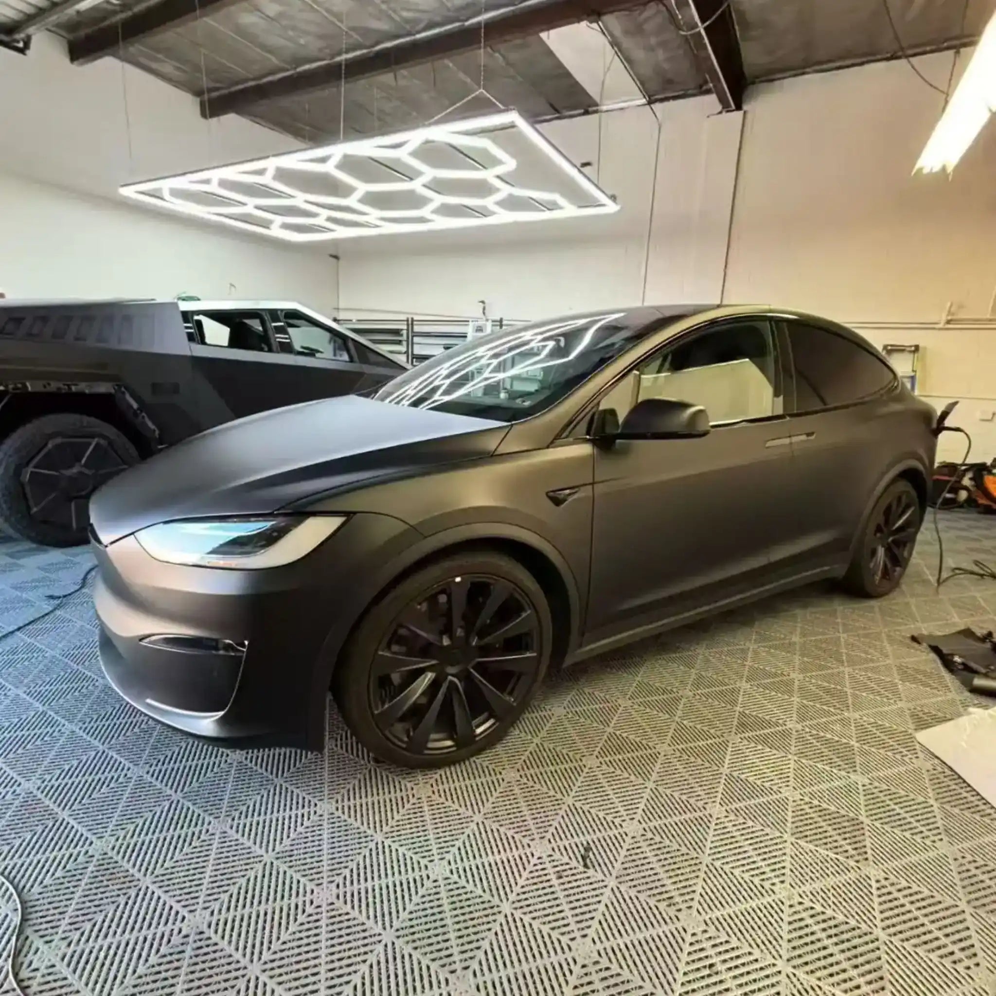 Tesla Model X in Stealth Matte Black vinyl - front-left indoor studio lighting - Kaleido