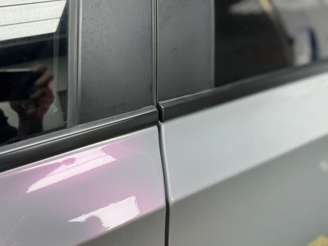 Macro shot of Volcanic Aura wrap on Honda Civic door - showing grey to pink flakes - Kaleido